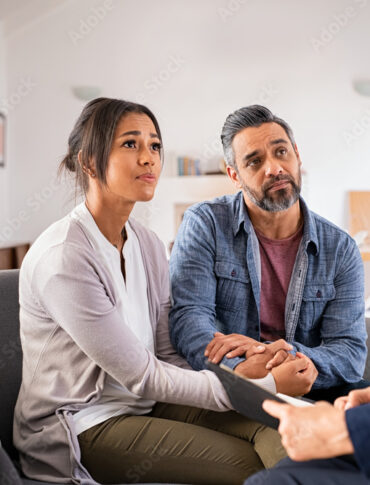Worried couple meeting social counselor